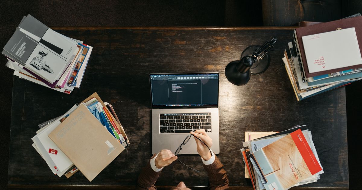 A student studying at a laptop with notes